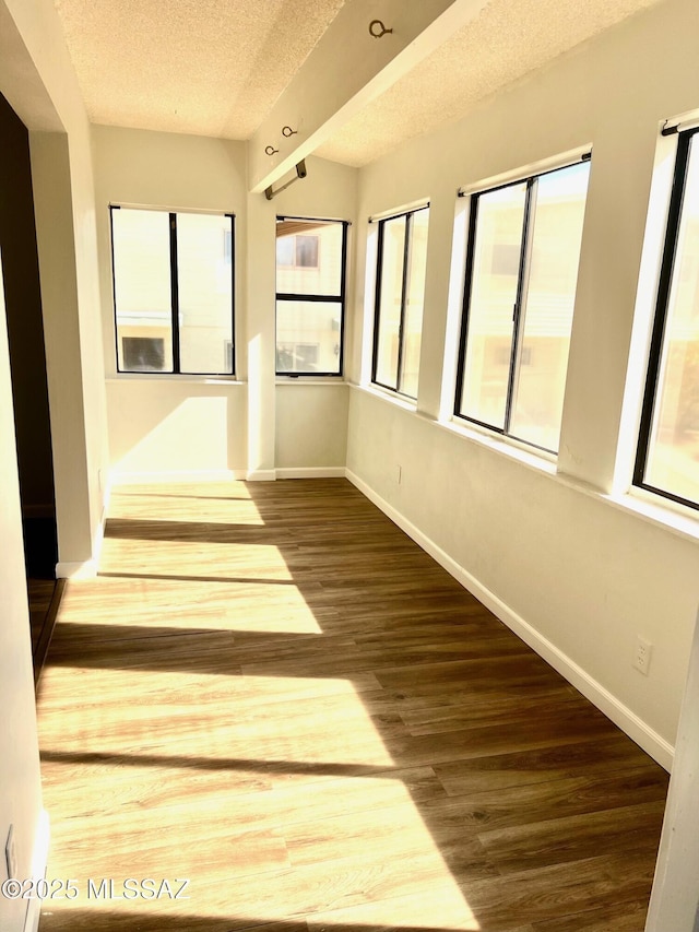 unfurnished room featuring hardwood / wood-style flooring and a textured ceiling