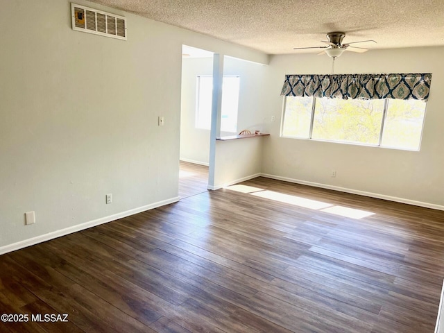 unfurnished room featuring dark wood-type flooring, ceiling fan, and a textured ceiling