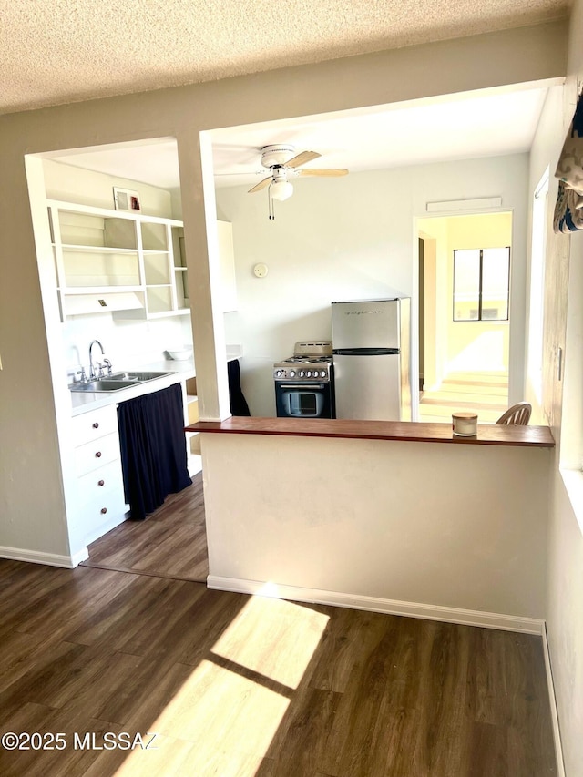 kitchen featuring appliances with stainless steel finishes, dark hardwood / wood-style floors, sink, and a textured ceiling