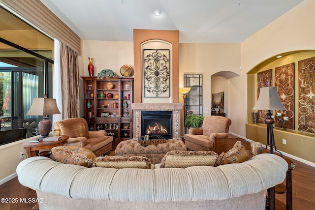 living room with a fireplace, wood finished floors, and baseboards