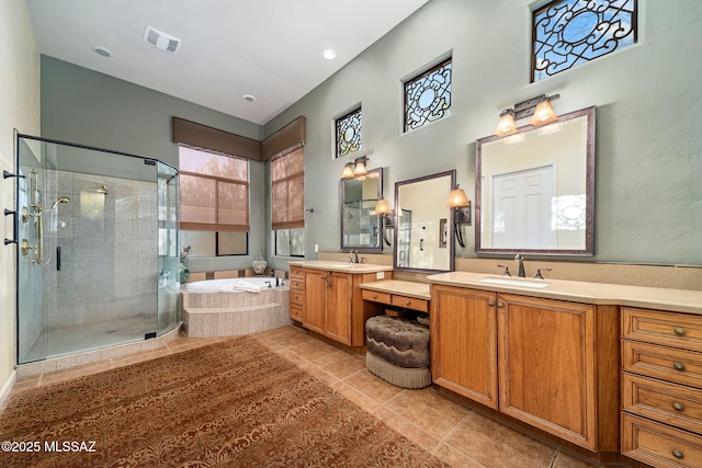 full bathroom with two vanities, visible vents, a shower stall, a bath, and tile patterned floors