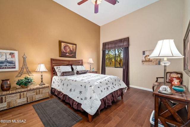 bedroom with ceiling fan, baseboards, vaulted ceiling, and wood finished floors