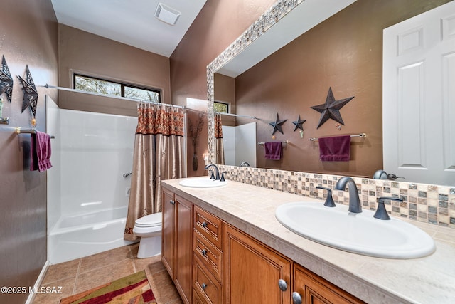 full bath with double vanity, a sink, toilet, and decorative backsplash