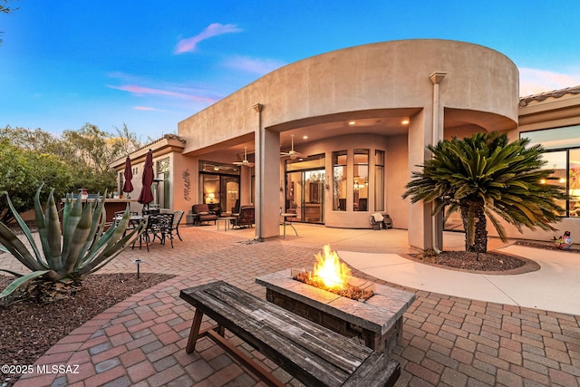 view of patio / terrace featuring a fire pit, outdoor dining area, and a ceiling fan