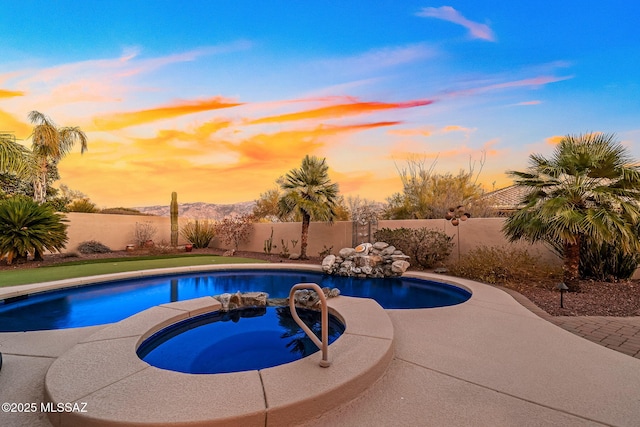 view of swimming pool with a fenced backyard, a fenced in pool, and an in ground hot tub