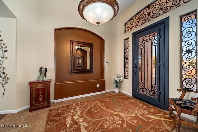 foyer entrance featuring baseboards and tile patterned floors