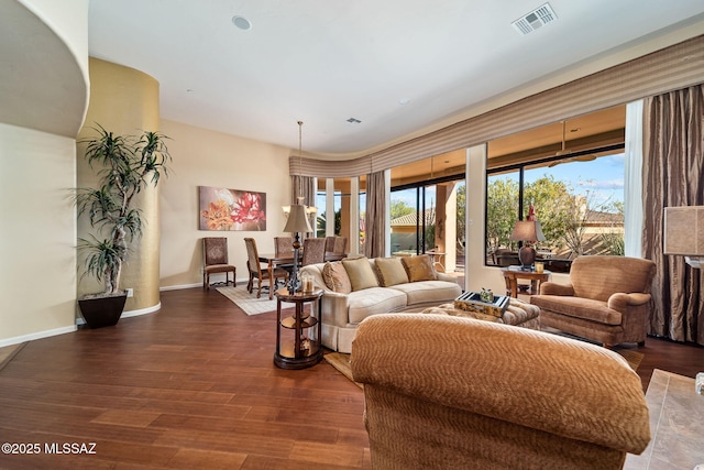 living area with visible vents, baseboards, and wood finished floors