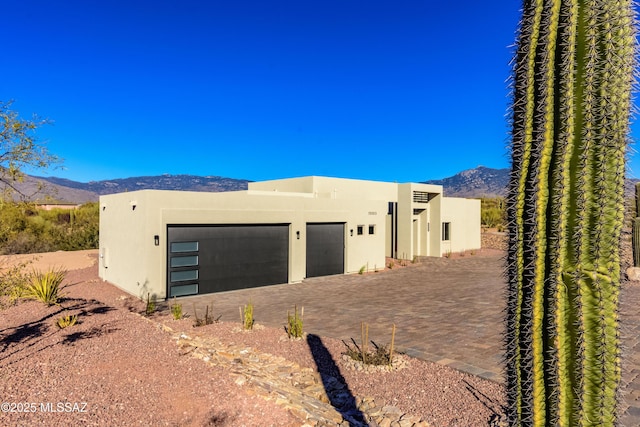 pueblo revival-style home featuring a garage and a mountain view