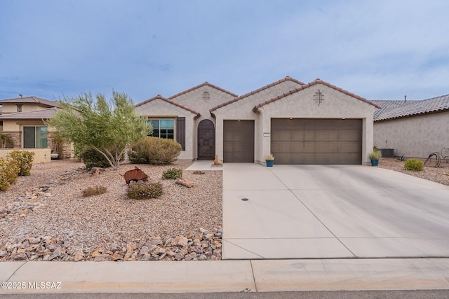 mediterranean / spanish-style home with a garage and central AC unit