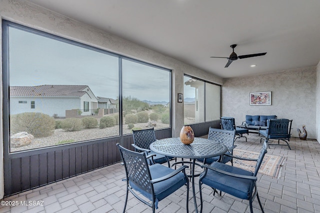 sunroom / solarium featuring ceiling fan