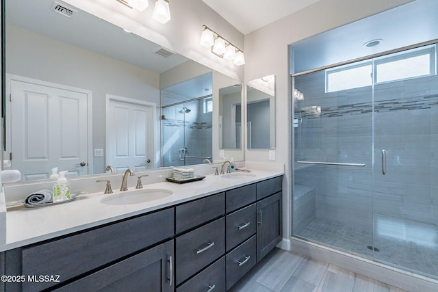 bathroom featuring vanity and a shower with shower door