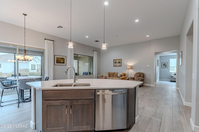 kitchen with a center island with sink, pendant lighting, sink, and stainless steel dishwasher