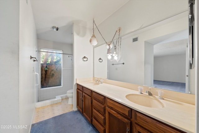 bathroom with walk in shower, vanity, and toilet