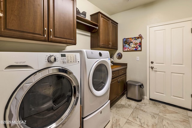 washroom with cabinets and washer and clothes dryer