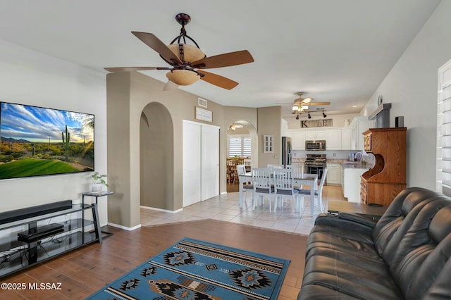 living room featuring ceiling fan and light hardwood / wood-style floors