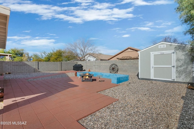 view of patio with a shed and an outdoor fire pit