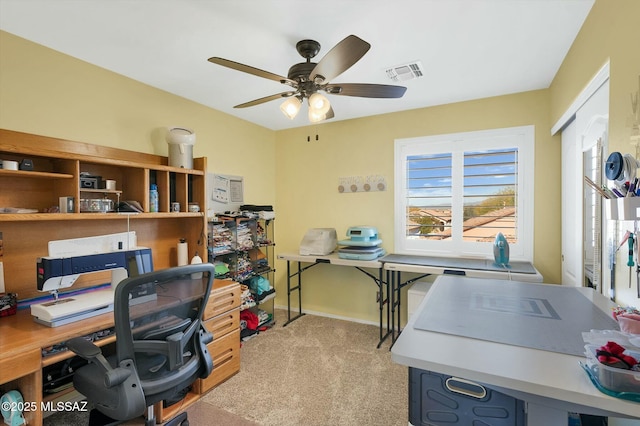 carpeted home office featuring ceiling fan