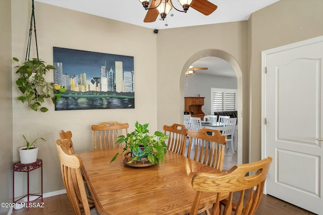 dining area with dark wood-type flooring and ceiling fan