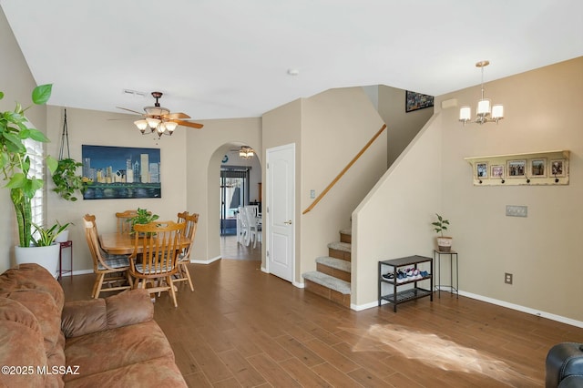 living room with ceiling fan with notable chandelier and hardwood / wood-style floors