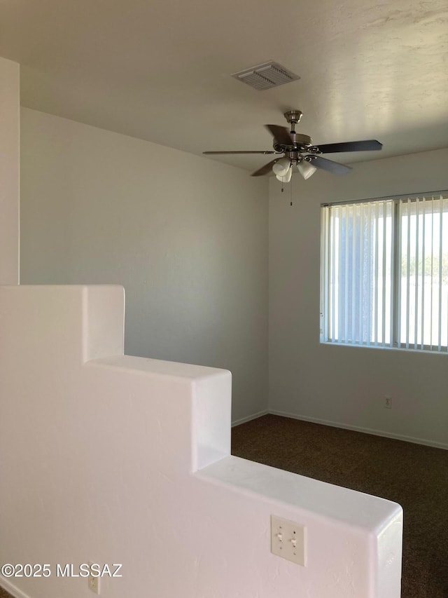 empty room with ceiling fan and carpet floors