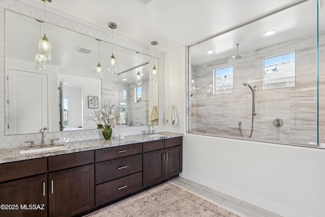 bathroom featuring tiled shower and vanity