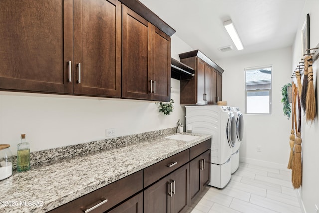 laundry room with cabinets, sink, and washing machine and dryer