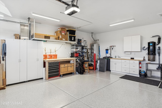 garage featuring a garage door opener, water heater, and a workshop area