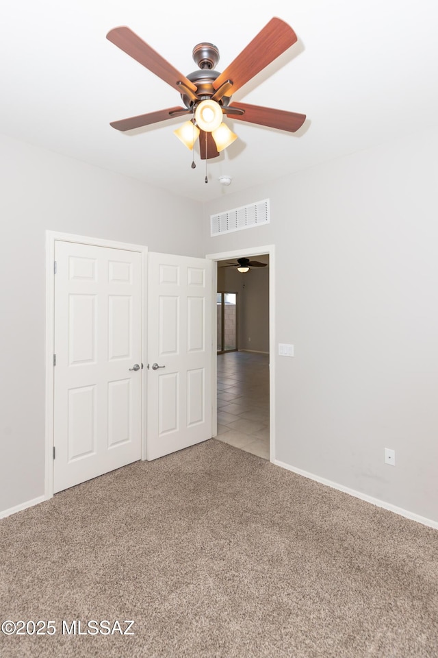 unfurnished bedroom featuring ceiling fan and carpet