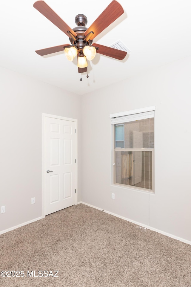 empty room featuring ceiling fan and carpet