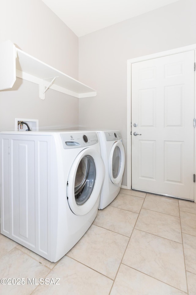 laundry area featuring light tile patterned flooring and independent washer and dryer