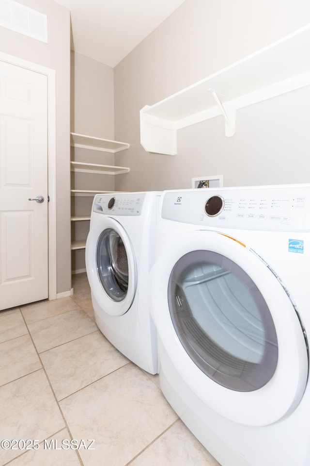 washroom featuring light tile patterned floors and washer and clothes dryer