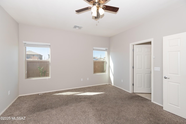 unfurnished room featuring carpet, a healthy amount of sunlight, and ceiling fan