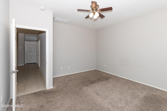 carpeted spare room with ceiling fan