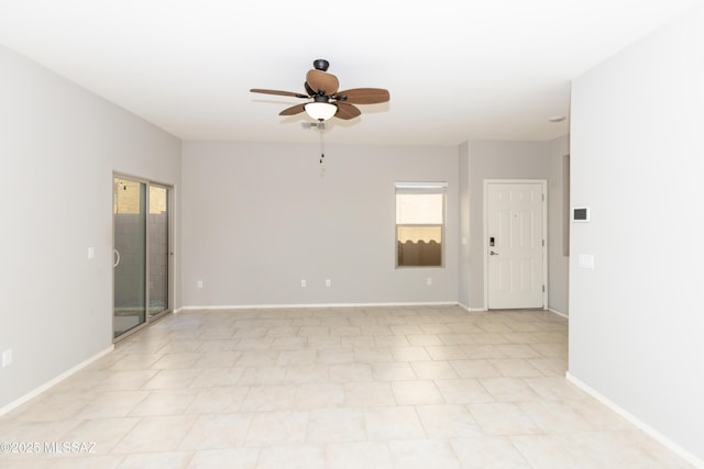 spare room featuring ceiling fan and plenty of natural light