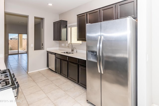 kitchen with dark brown cabinetry, appliances with stainless steel finishes, sink, and light tile patterned floors