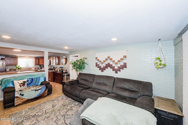 living area featuring recessed lighting, brick wall, and light tile patterned floors