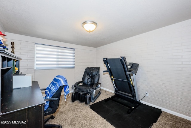 carpeted office space with baseboards and brick wall