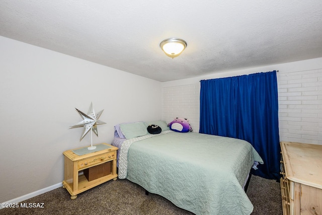 bedroom with baseboards, dark carpet, and a textured ceiling