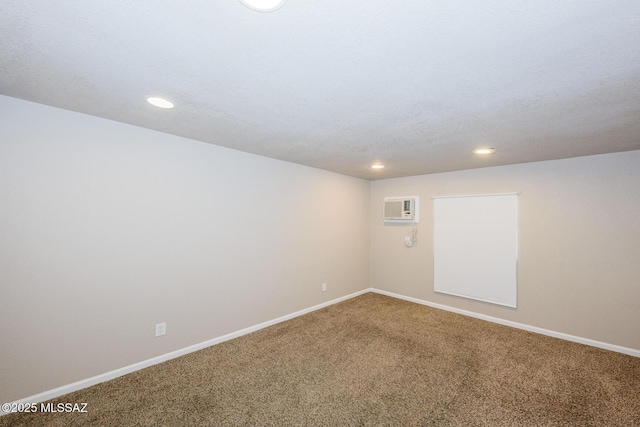 spare room featuring an AC wall unit, recessed lighting, carpet flooring, and baseboards