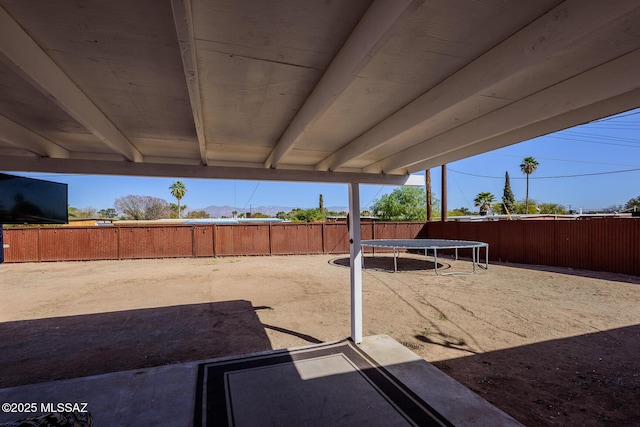 view of patio featuring a fenced backyard and a trampoline