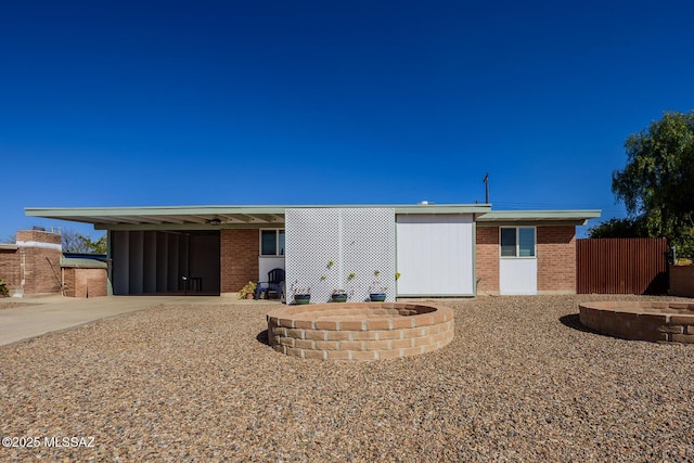 view of front facade with a carport, brick siding, and concrete driveway