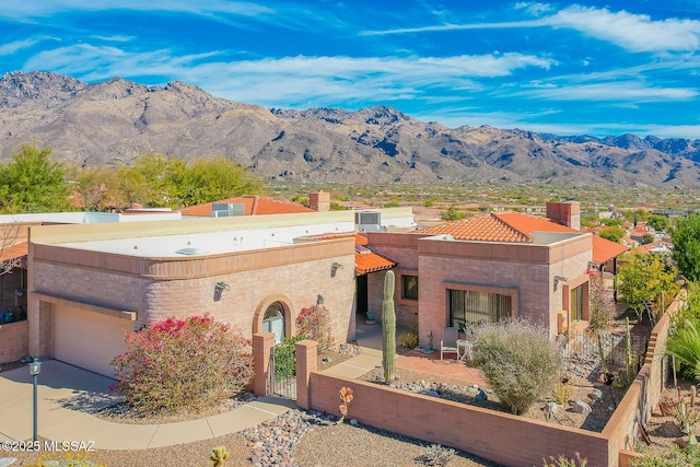 view of front of house featuring a gate, a mountain view, driveway, and fence