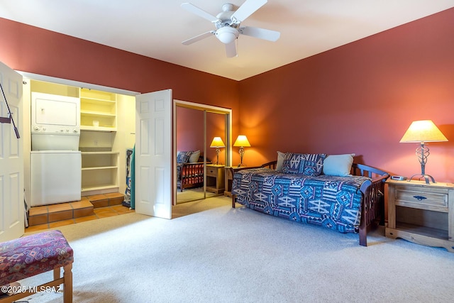 bedroom with stacked washer and dryer, carpet, and a ceiling fan