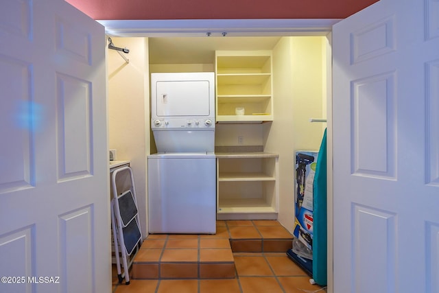 laundry area featuring light tile patterned floors and stacked washer / dryer