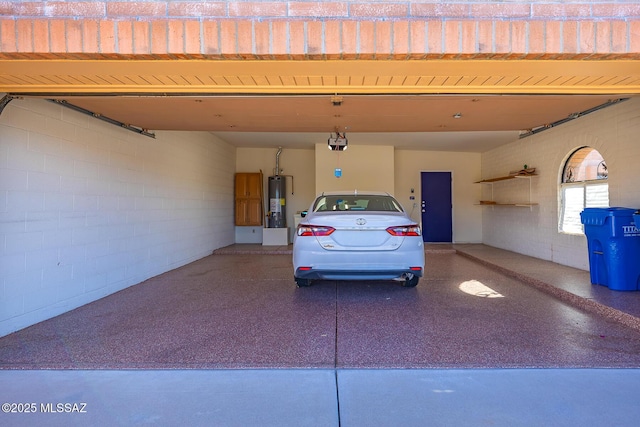 garage with driveway, water heater, and a garage door opener