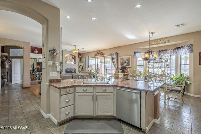 kitchen featuring light stone countertops, plenty of natural light, and stainless steel dishwasher