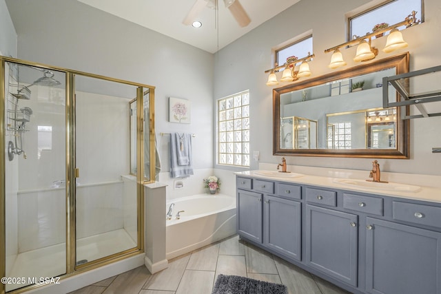 bathroom featuring independent shower and bath, vanity, and ceiling fan