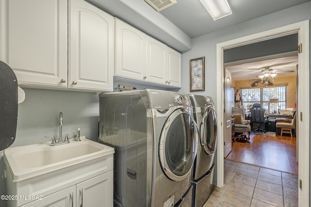 laundry area with light tile patterned flooring, sink, cabinets, ceiling fan, and washer and clothes dryer