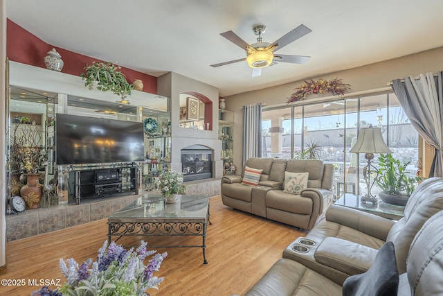 living room with ceiling fan, hardwood / wood-style floors, and a fireplace