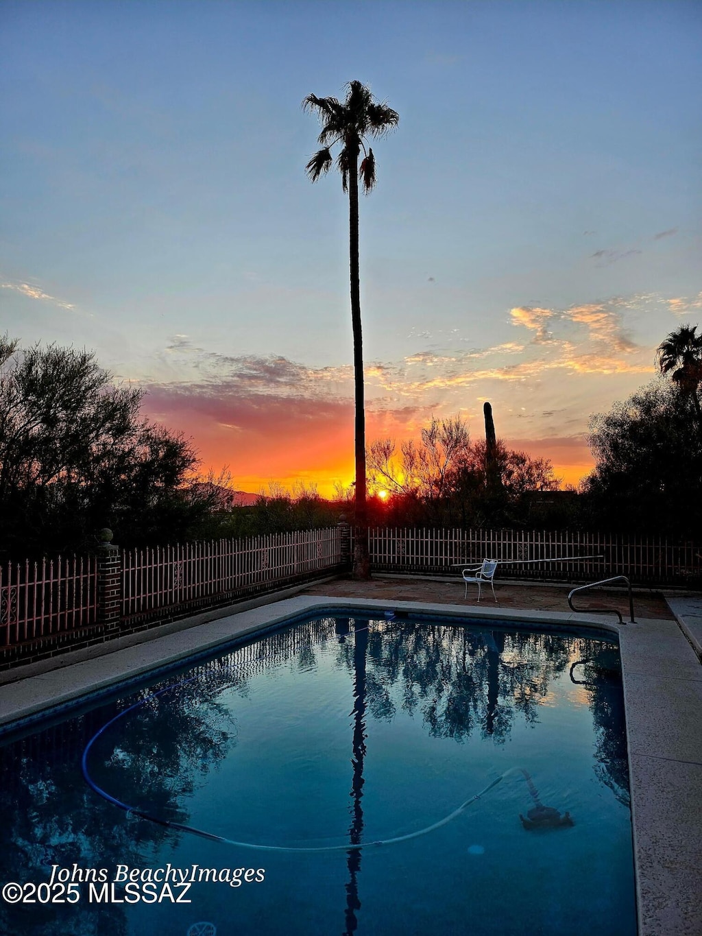 pool at dusk with a patio